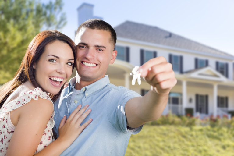 Mixed Race Excited Military Couple In Front of New Home Showing Off Their House Keys.